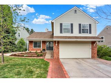 Charming two-story home with brick accents, a well-manicured lawn, and a welcoming red brick pathway at 2246 Mountain Sage Dr, Highlands Ranch, CO 80126