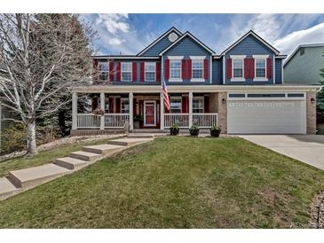 Charming two-story home with a welcoming front porch and well-manicured lawn at 10046 Brisbane Ln, Highlands Ranch, CO 80130