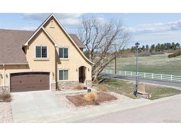 Charming home featuring a two-car garage, stone accents and manicured front yard at 1890 Bel Lago Vw, Monument, CO 80132