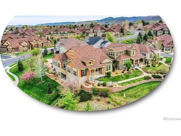 Beautiful two-story home with lush landscaping, stone accents, and a mountain backdrop at 5781 S Union Ter, Littleton, CO 80127