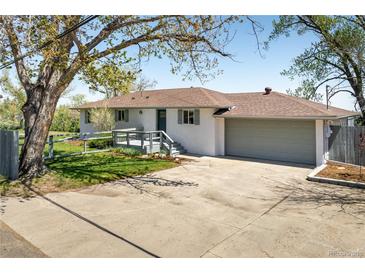 Charming home featuring a welcoming front porch and an attached two-car garage on a sunny day at 4972 Easley Rd, Golden, CO 80403