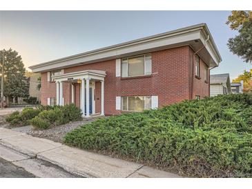 Brick building with a classic design, featuring a blue door and well-maintained landscaping at 450 W Jefferson Ave, Englewood, CO 80110