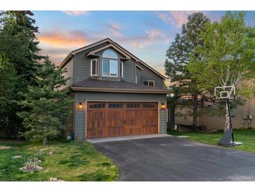 Charming two-story home with a well-manicured lawn and a two-car garage at 24005 High Meadow Dr, Golden, CO 80401