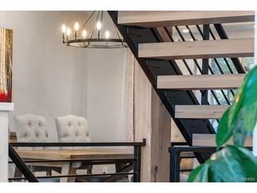 Modern staircase with wood steps, iron risers, and pendant lighting providing an architectural focal point at 24005 High Meadow Dr, Golden, CO 80401