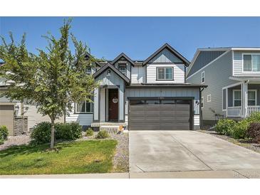 Two-story house with gray and white siding, attached garage, and landscaped front yard at 27891 E 7Th Ave, Aurora, CO 80018