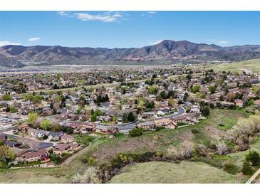 Expansive aerial view of neighborhood homes with beautiful mountain views in the distance on a sunny day at 2140 S Coors Cir, Lakewood, CO 80228