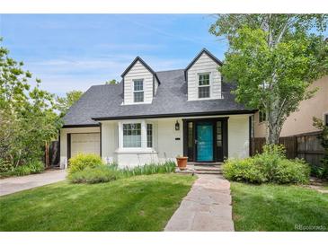 Charming two-story home with a well-maintained front yard, stone walkway, and inviting blue front door at 1016 S Cook St, Denver, CO 80209