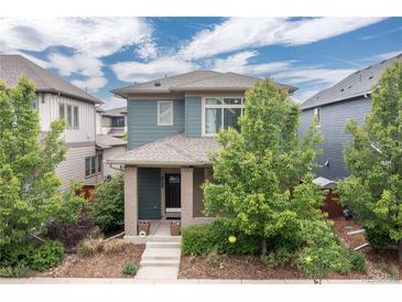 Charming two-story home featuring professionally landscaped front yard and welcoming front porch at 8768 E 54Th Pl, Denver, CO 80238