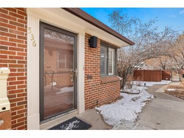 Charming brick home with a glass front door, showcasing its welcoming facade and curb appeal at 536 Detroit St, Denver, CO 80206