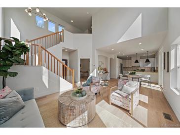 Bright living room featuring a modern staircase, wood floors, and lots of natural light at 5586 S Harlan St, Littleton, CO 80123