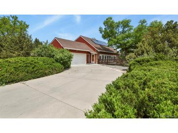 Charming two-story home with a large driveway, mature trees, and professionally landscaped yard at 4664 S Union St, Morrison, CO 80465