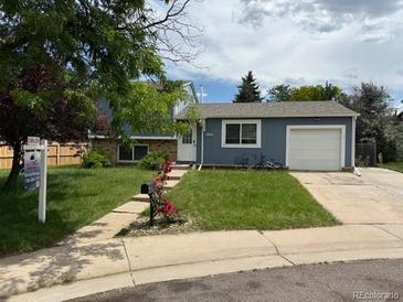 Charming single-story home featuring a well-manicured lawn, inviting front yard, and a paved driveway to the attached garage at 4259 S Richfield St, Aurora, CO 80013