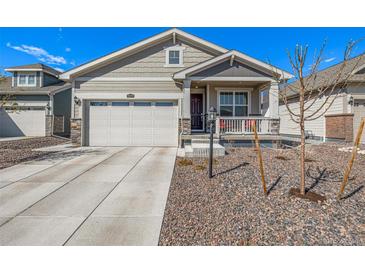 Charming one-story home featuring stone accents, neutral siding, a front porch, a well-maintained lawn, and an attached garage at 15979 Xanthia Way, Thornton, CO 80602