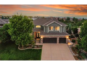 Two-story home with landscaped yard and attached three-car garage at 5965 Topaz Vista Pl, Castle Pines, CO 80108