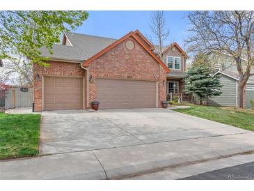 Charming two-story brick home featuring a three-car garage and a well-maintained front yard with mature trees at 13131 Pennsylvania St, Thornton, CO 80241
