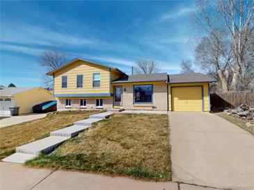 Charming yellow two-story home with an attached one-car garage and a well-maintained front yard at 4487 S Alkire St, Morrison, CO 80465