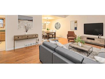 Bright open-concept living room with hardwood floors and dining area at 6047 Vivian Ct, Arvada, CO 80004