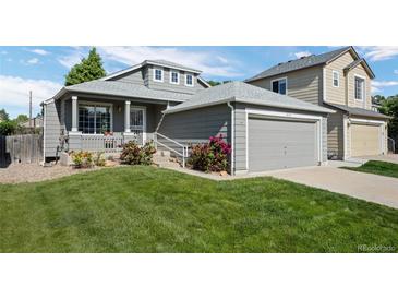 Charming gray home featuring an attached garage and a well-maintained lawn at 8761 Cloverleaf Cir, Parker, CO 80134