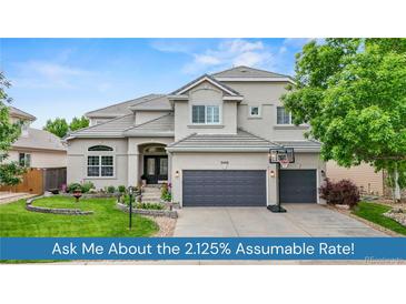 Stunning two-story home featuring a well-manicured lawn, elegant architecture, and a three-car garage at 9468 E Aspen Hill Ln, Lone Tree, CO 80124
