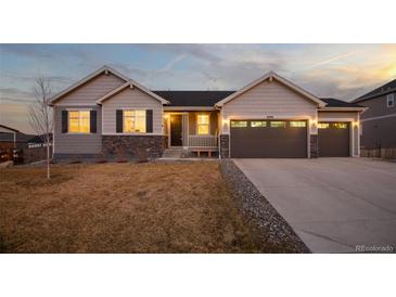 Charming two-story home boasts great curb appeal, neutral paint, stone accents, three-car garage and meticulously manicured lawn at 6766 Mentha Dr, Castle Rock, CO 80108