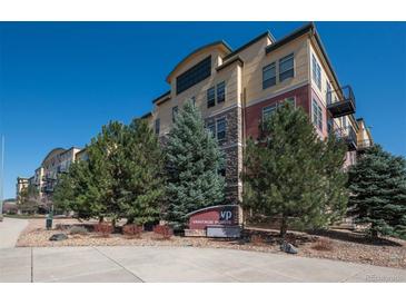 Attractive multi-story building with mature landscaping and clear blue sky at 13456 Via Varra # 208, Broomfield, CO 80020