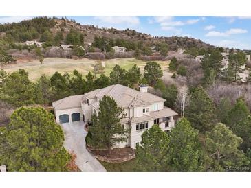 Expansive estate on a lush green golf course with mature trees and beautiful landscaping at 937 Aztec Dr, Castle Rock, CO 80108