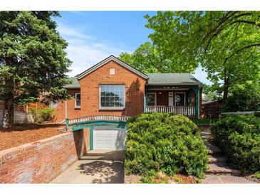 Charming brick home with well-maintained landscaping, a quaint front porch, and a unique arched access to the below grade garage at 40 Colorado Blvd, Denver, CO 80206