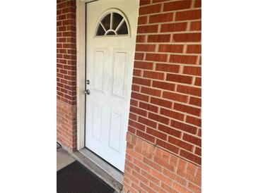 Arched white front door nestled in a classic red brick facade at 9041 Lilly Ct, Thornton, CO 80229