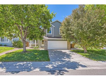 Charming two-story home with a well-maintained lawn, mature trees, and a two-car garage at 728 Poppywood Pl, Highlands Ranch, CO 80126