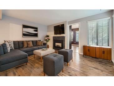 Comfortable living room featuring a fireplace, hardwood floors, and a gray sectional sofa at 836 S Vance St # D, Lakewood, CO 80226