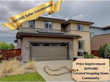 Charming two-story home featuring a two car garage, stone accents, and mature landscaping at 10906 Touchstone Loop, Parker, CO 80134