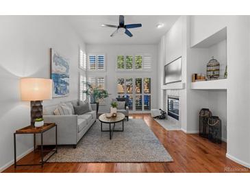 Bright living room boasts a fireplace, hardwood floors, and lots of natural light at 9491 Southern Hills Cir, Lone Tree, CO 80124