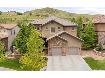 Gorgeous home boasts a two-car garage, beautiful landscaping, and a hill view, offering a blend of luxury and nature at 14841 W Warren Ave, Lakewood, CO 80228