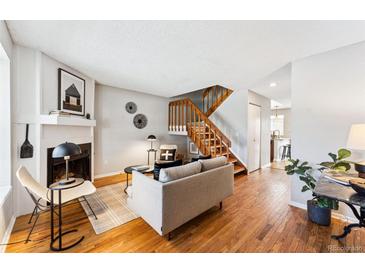 Inviting living room featuring hardwood floors, a fireplace, and staircase at 4626 S Dillon Ct # B, Aurora, CO 80015