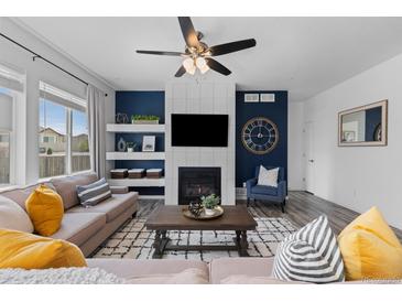 Inviting living room features a fireplace, ceiling fan, and stylish decor for a cozy and modern feel at 17960 Weymouth Ave, Parker, CO 80134