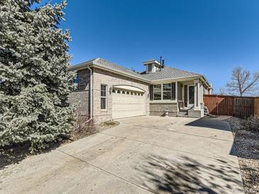Charming exterior view of a brick home with a well-maintained front yard and large shade tree at 24704 E Chenango Dr, Aurora, CO 80016