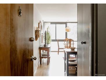 Entryway view showcasing an inviting space with hardwood floors and dining area at 1050 N Corona St # 312, Denver, CO 80218
