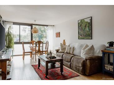 Bright living room featuring hardwood floors, modern furniture, and large windows at 1050 N Corona St # 312, Denver, CO 80218