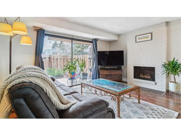 Inviting living room with brick fireplace, sliding glass doors, and comfortable seating arrangement at 7995 E Mississippi Ave # C11, Denver, CO 80247