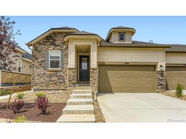 Charming home featuring a stone facade, tan siding, attached garage, and well-manicured landscaping at 3461 N Buchanan Way, Aurora, CO 80019