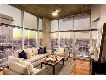 Bright living room with floor-to-ceiling windows offering stunning city views and hardwood floors at 1700 Bassett St # 2117, Denver, CO 80202
