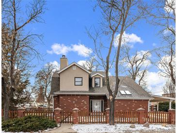 Brick house with a fenced yard and mature trees at 4401 S Lincoln St, Englewood, CO 80113