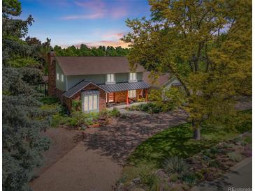 Charming two-story home with landscaped yard and inviting front porch shaded by mature trees on a sprawling lot at 1579 W Costilla Pl, Littleton, CO 80120