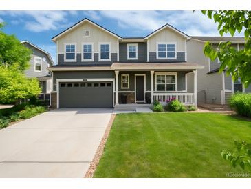 Beautiful two-story home features a well-manicured lawn, spacious driveway, and charming covered front porch at 3027 Walnut Grove St, Erie, CO 80516