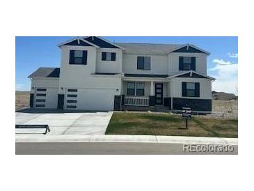 Charming two-story home with a three-car garage, blue roof accents, and landscaped yard at 42980 Colonial Trl, Elizabeth, CO 80107