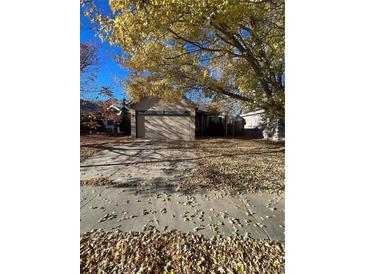 Ranch-style home with two-car garage and mature trees in the front yard at 4063 S Himalaya Way, Aurora, CO 80013
