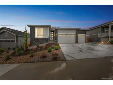 Beautiful single-story home featuring a three-car garage, stone accents, and professional landscaping at 1148 Sunlit Dr, Castle Rock, CO 80109