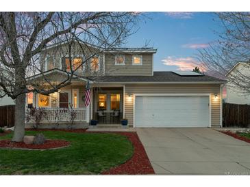 Charming two-story home featuring a well-manicured lawn, a welcoming porch, and a two-car garage at 2085 E 127Th Pl, Thornton, CO 80241