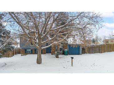 Ranch style home with blue garage door and snowy front yard at 2402 S Lewiston St, Aurora, CO 80013