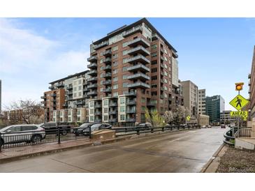 Modern brick condo building featuring multiple balconies, city views, and street access at 1401 Wewatta St # 311, Denver, CO 80202